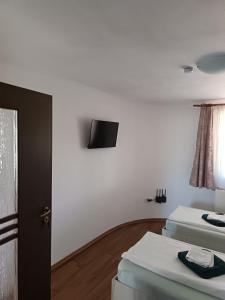 a room with two beds and a television on the wall at Casa Borza in Alba Iulia