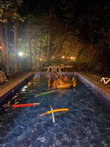 a swimming pool with surfboards in the water at night at Villa Concepcion Staycation by ngb in Real