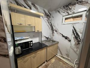 a small kitchen with a black and white marble wall at Apartment Registon in Samarkand