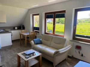 a living room with a couch and a table at Ferienwohnungen Arkonablick in Lohme