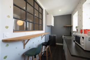 a kitchen with a counter and two stools at Les Brimbelles in Brû +41 photos