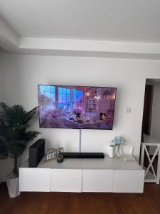a living room with a tv on a white wall at Cytonn unique suits in Ruaka +2 photos