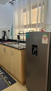 a kitchen with a refrigerator next to a counter at Cytonn unique suits in Ruaka