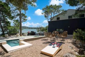 a backyard with a table and chairs and a pool at Villa L'aron in Bilice