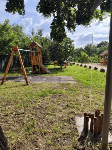 a playground with a swing set in a park at Levendula Vendégház - Bezi in Bezi