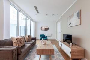a living room with a couch and a tv at Modern 1Bed Flat in Ealing Near Tube & Shops in Ealing