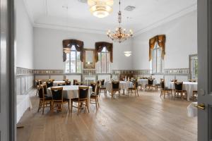 a dining room with tables and chairs and a chandelier at Brodremenighedens Hotel, BW Signature Collection in Christiansfeld
