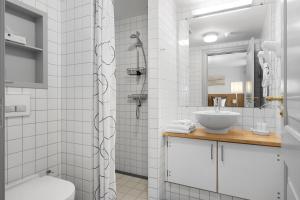 a white bathroom with a sink and a shower at Brodremenighedens Hotel, BW Signature Collection in Christiansfeld +58 photos