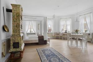 a white room with a bed and a dining room at Brodremenighedens Hotel, BW Signature Collection in Christiansfeld