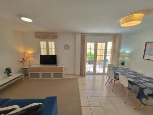 a living room with a table and chairs and a television at Las Casitas de la Playa in Vera