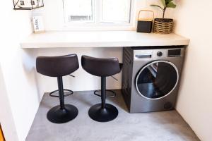 two chairs under a counter next to a washing machine at Hilton Hideaway in Hilton