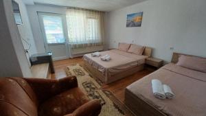 a living room with two beds and a couch at Вила Багрянови in Dospat +6 photos