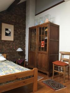 a bedroom with a bed and a wooden cabinet at La Vigne - Han-sur-Lesse in Han-sur-Lesse