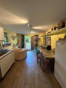 a kitchen and living room with a table and a couch at Annexe in Broomfield Barn in Swettenham