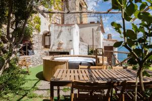 a patio with a wooden table and a fireplace at Casa Zia Adele in Erchie