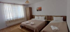a bedroom with two beds with towels on them at Вила Багрянови in Dospat