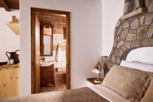 a bedroom with a bed and a bathroom with a sink at Infinito Boathouse Milos in Agia Irini Milos