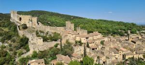 a village on a hill with a castle at Gîte climatisé "Baugallo Accordailles" in Saint-Montan