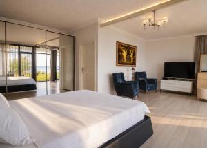 a bedroom with a bed and two chairs and a television at Palm Beach Şile Villa Hotels in Şile