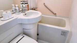 a white bathroom with a sink and a toilet at Hotel Paco Obihiro Ekimae in Obihiro +27 photos