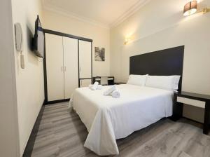 a bedroom with a large white bed with towels on it at Alhambra Suites in Madrid