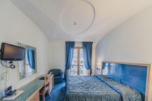 a bedroom with a blue bed and a window at Aragona Palace Hotel & Spa in Ischia Town +40 photos