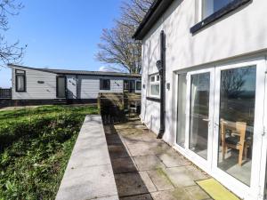 a patio outside of a house with windows and chairs at Beacon Fell Cottage 2 in Preston