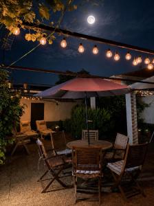 a table with chairs and an umbrella on a patio at El Patio de Polán in Polán