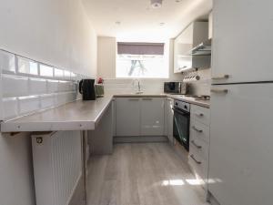 a kitchen with white cabinets and a sink and a window at Beacon Fell Cottage 2 in Preston