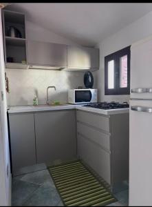 a small kitchen with a stove and a microwave at Casa Del Marinaio in Cala Gonone