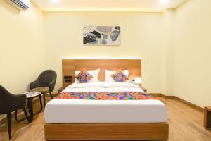 a bedroom with a large bed and two chairs at FabHotel Prime The Ballroom - Near GD Goenka University in Gurgaon +28 photos