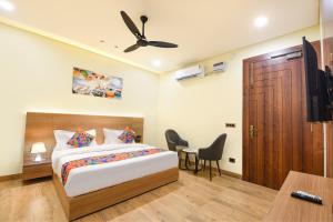 a bedroom with a bed and a desk and a television at FabHotel Prime The Ballroom - Near GD Goenka University in Gurgaon
