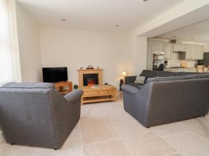 a living room with two couches and a tv at Naseby House in Alfreton