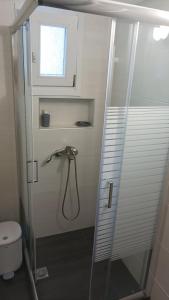 a bathroom with a shower with a toilet and a window at SpoonLand in Néa Koútali +16 photos