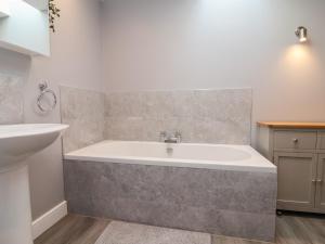 a bathroom with a bath tub and a sink at Naseby House in Alfreton +25 photos