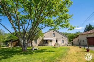 an old house with a tree in the yard at L' ebénisterie in Tocane-Saint-Apre