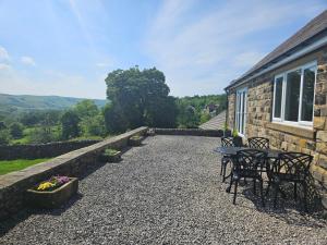 a patio with a table and chairs in front of a building at Thorn Tree Cottage in Hope