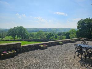 a table and chairs on a patio with a view at Thorn Tree Cottage in Hope