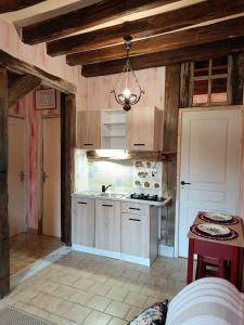 a kitchen with white cabinets and a table in a room at La fermette de Vrinette in Saint-Vérain