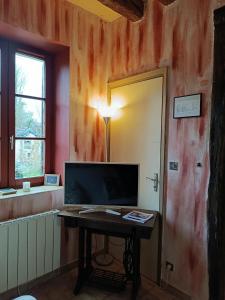 a room with a table and a television and a door at La fermette de Vrinette in Saint-Vérain
