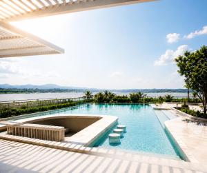 a swimming pool with a view of the water at BTP Hotel Nakhon Phanom in Ban Noi Pho Kham