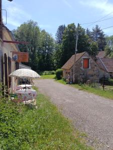 a table with an umbrella on the side of a road at La fermette de Vrinette in Saint-Vérain