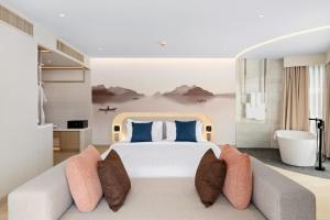 a bedroom with a large bed and a couch at BTP Hotel Nakhon Phanom in Ban Noi Pho Kham