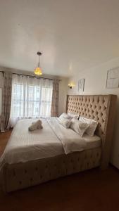 a large bed in a bedroom with a large window at Best west residence in Ruaka