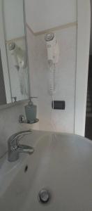 a bathroom sink with a mirror and a hair dryer at La casa delle fate in Lusevera