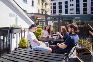 a group of people sitting at tables on a patio at The Dawson Hostel Galway in Galway