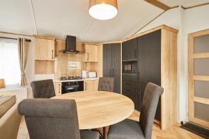 a kitchen and dining room with a wooden table and chairs at Host & Stay - Rose Lodge in Pocklington