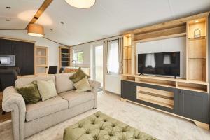 a living room with a couch and a flat screen tv at Host & Stay - Rose Lodge in Pocklington