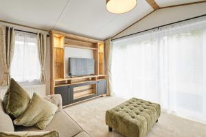 a living room with a couch and a tv at Host & Stay - Rose Lodge in Pocklington +20 photos
