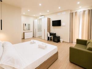 a bedroom with a large white bed and a couch at AWA Kafara in Porticello